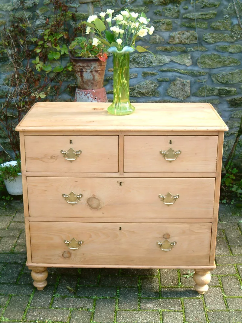 Image of front of antique pine chest of drawers, with floral decoration.