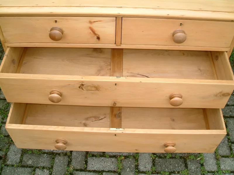Image of the centre drawers open on the old pine chest, showing the timber drawer bases.